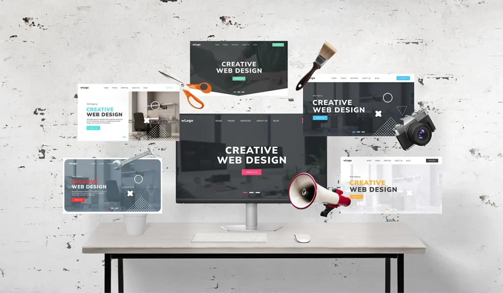 Multiple web design layouts displayed around a desktop monitor in a creative workspace